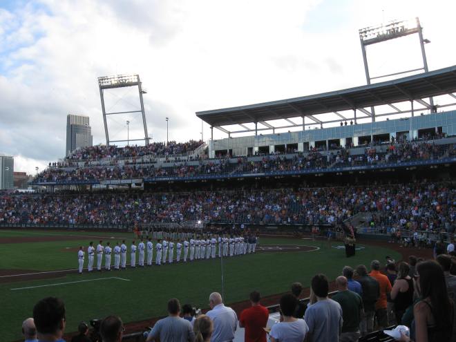 The Florida Gators (in white) and Miami Hurricanes salute the colors before Game Two of the 2015 College World Series.